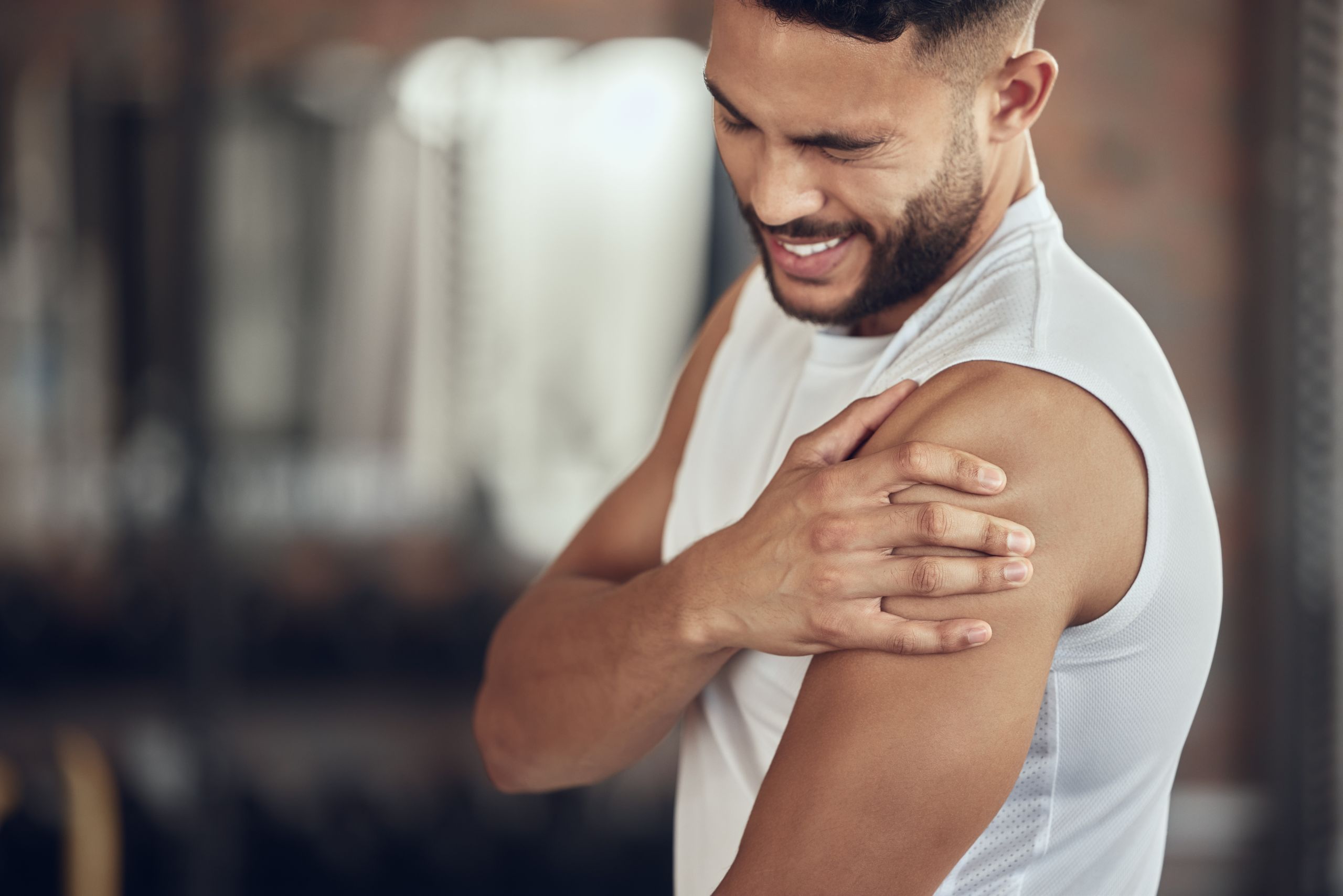 Chiropractor assessing shoulder pain and mobility in patient