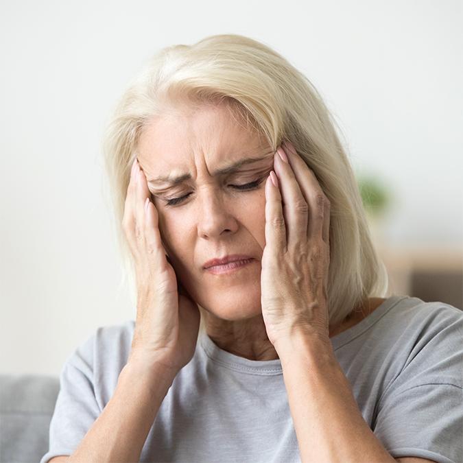 Person experiencing migraine pain with light sensitivity