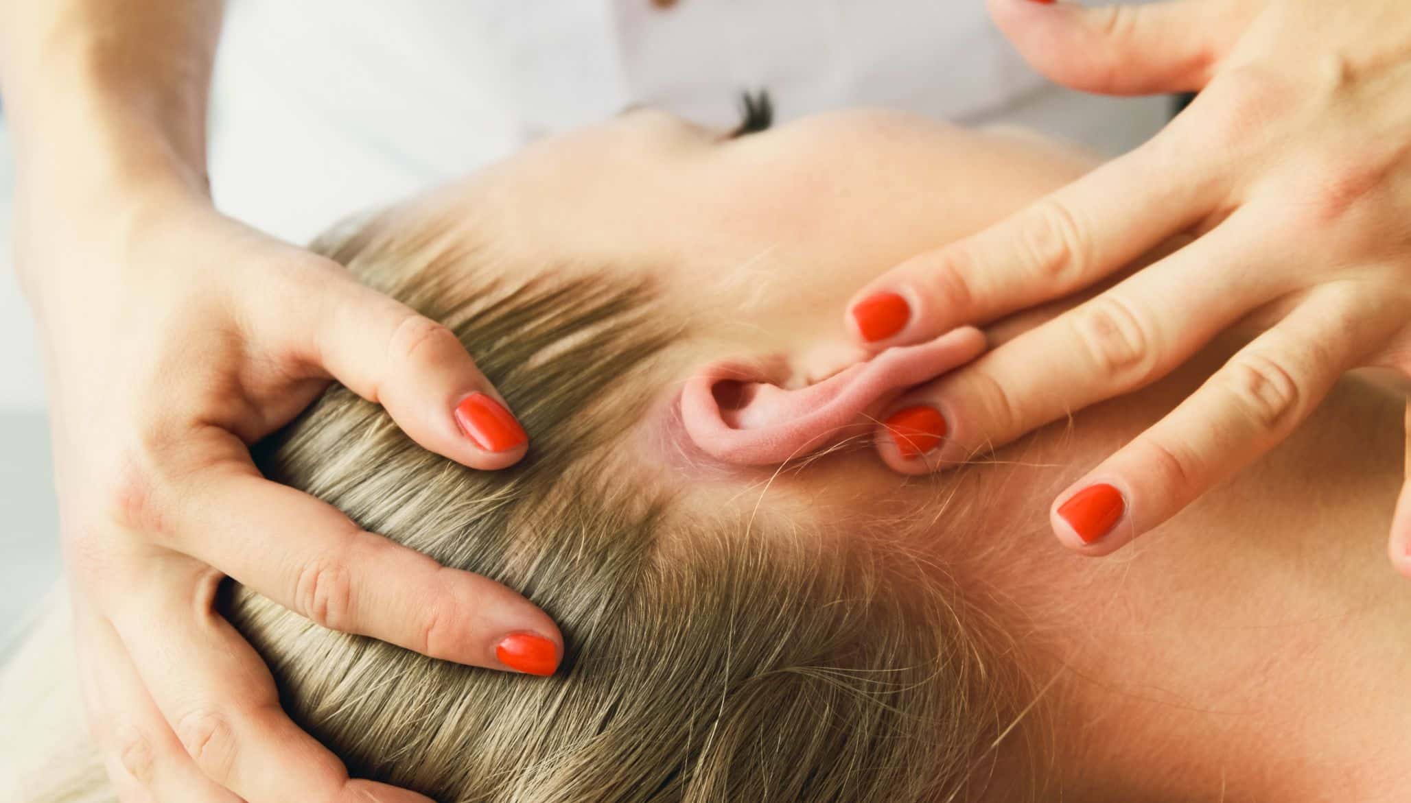 Therapist performing gentle ear and head technique for vestibular physiotherapy treatment