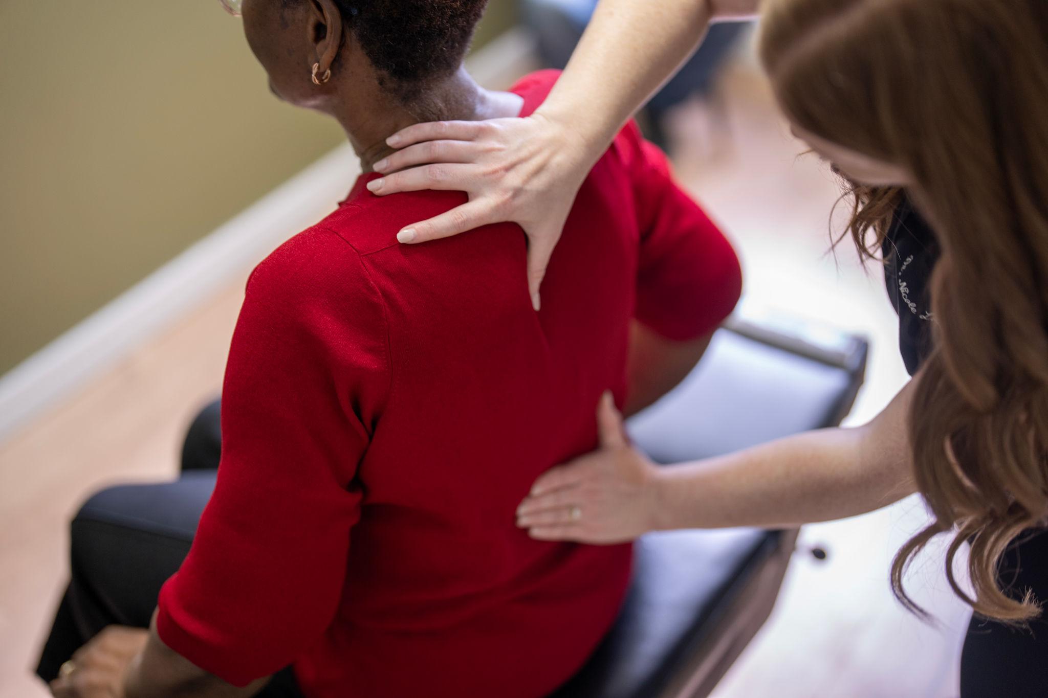 Person holding lower back in pain due to poor posture or muscle strain